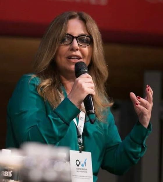 Claudia Fernandes falando ao microfone em painel executivo